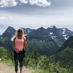 Woman standing on mountain against sky