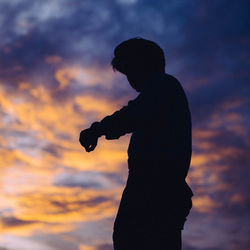 Silhouette woman standing against sky during sunset
