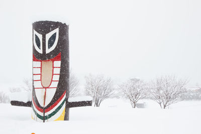 Information sign on snow covered field against sky