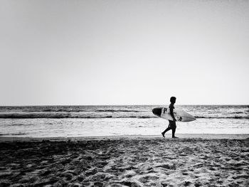 Woman on beach against clear sky