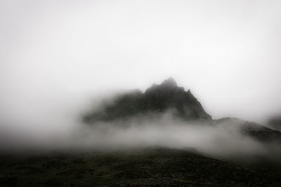 Scenic view of foggy weather against sky