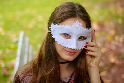 Close-up portrait of smiling young woman wearing venetian mask