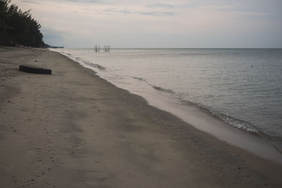 Scenic view of beach against sky at sunset