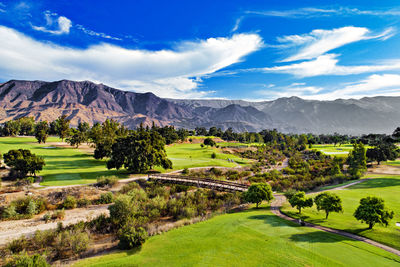 Scenic view of golf course against sky