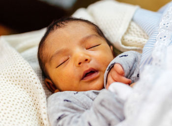 Close-up of baby boy sleeping on bed at home