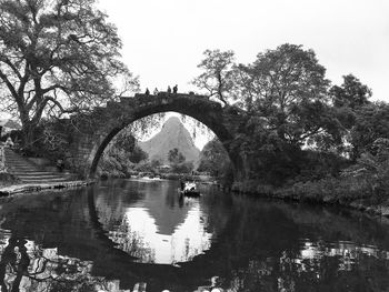 Arch bridge over lake against sky