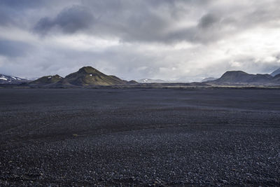 View of desert against cloudy sky