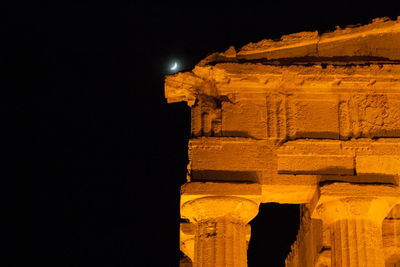 Low angle view of illuminated building against sky at night