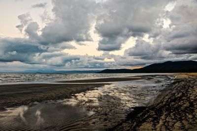 View of beach against cloudy sky