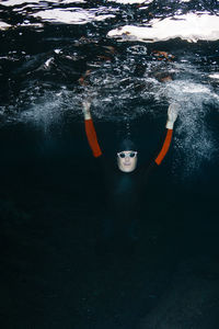 Male swimmer looking at camera while diving in sea