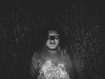 Portrait of young woman with horse at night