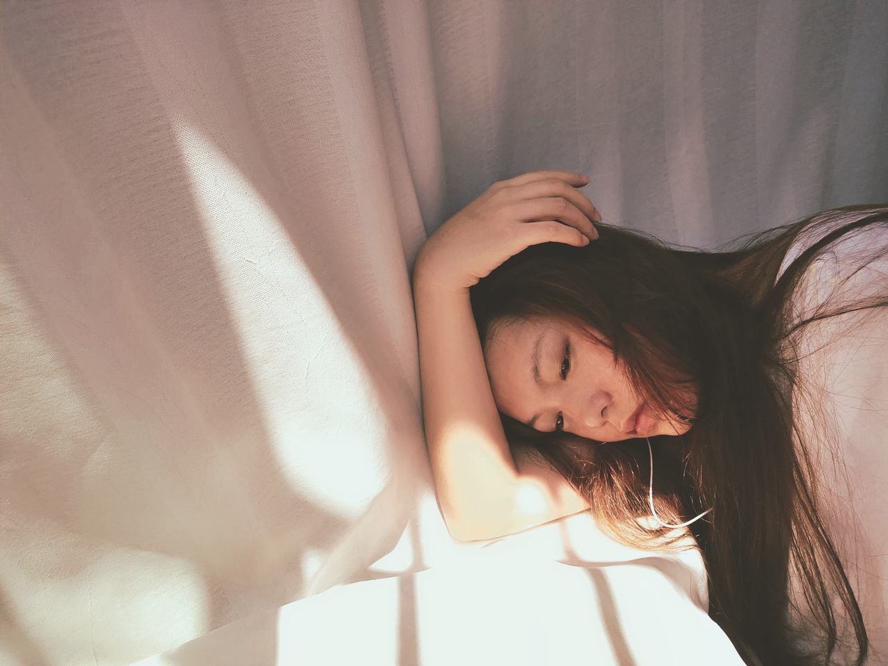 PORTRAIT OF YOUNG WOMAN SLEEPING IN BED
