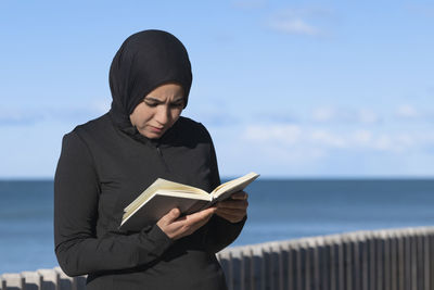 Young woman using mobile phone at beach