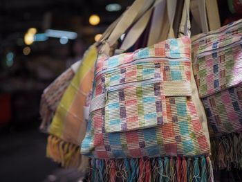 Close-up of sling bags hanging at market stall