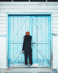 Man standing by closed door of building