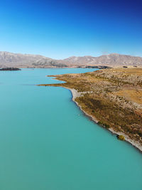 Scenic view of lake against clear blue sky