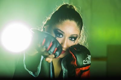 Portrait of woman holding illuminated lighting equipment