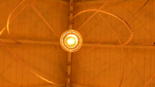 Low angle view of illuminated light bulbs hanging from ceiling