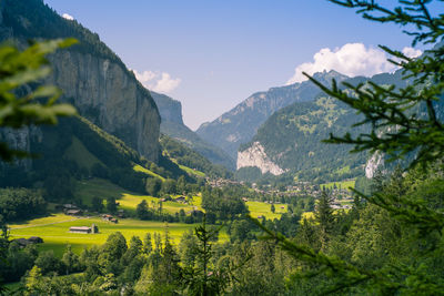 Scenic view of agricultural field by mountains against sky