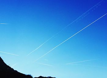 Low angle view of power lines against blue sky