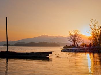 Sailboats in lake against sky during sunset