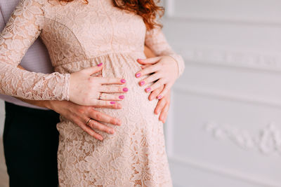 Midsection of couple standing at home