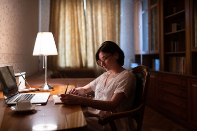 Female student making notes at home