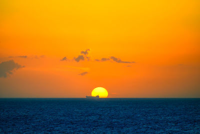 Scenic view of sea against orange sky