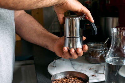 Man preparing classic italian coffee in the mocha in the kitchen. coffee brake. morning habit.