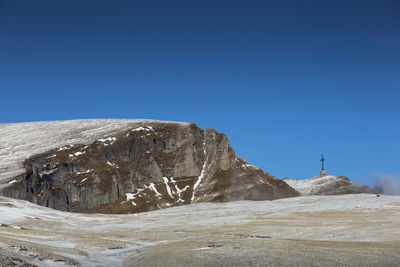 Rock formations against clear blue sky