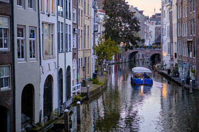 Sightseeing boat tour on the oudegracht canal in utrecht city centre. autumn evening.