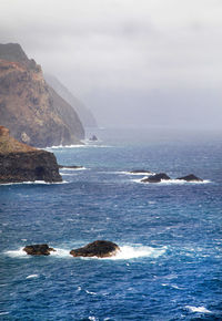 Rock formations on sea against sky