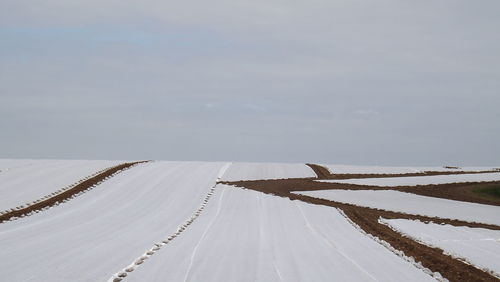 Snow covered field against sky