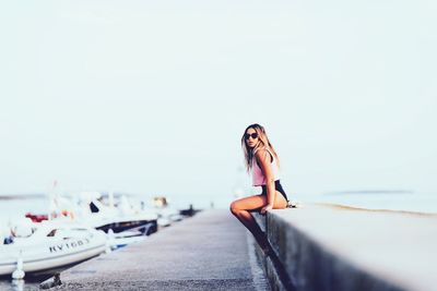 Young woman sitting on retaining wall