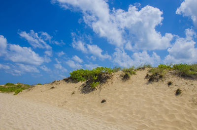 Scenic view of sand dunes against sky