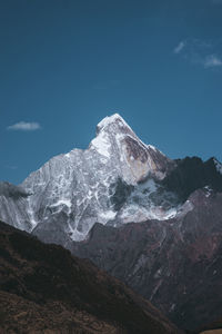 Scenic view of snowcapped mountain against blue sky