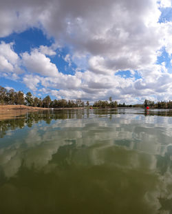 Reflection of building in lake against sky