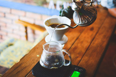 Cropped hand of man preparing coffee on table