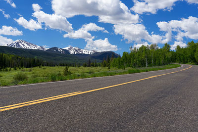 Road by mountains against sky