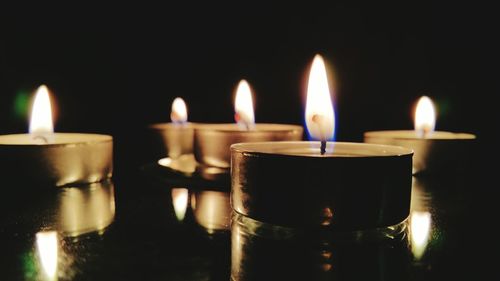 Close-up of lit candle in dark room