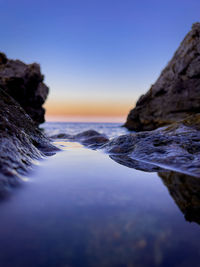 Scenic view of sea against clear sky at sunset