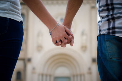 Midsection of couple holding hands