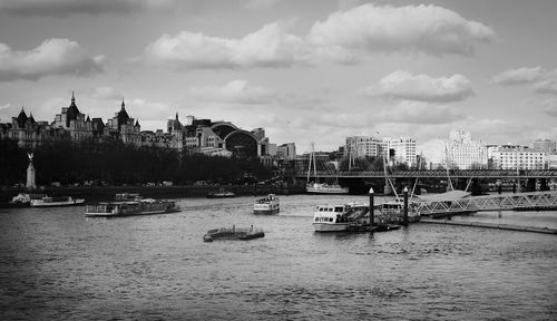 Boats in river with city in background