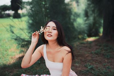 Young woman wearing mask on field in forest