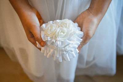 Close-up of hand holding white rose