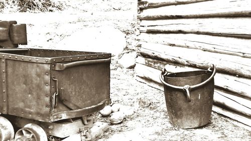 Close-up of old garbage can against wall