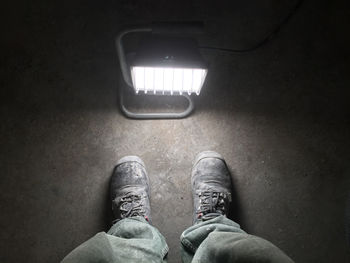 Low section of man standing in illuminated room