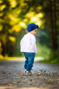 Rear view of girl standing on road