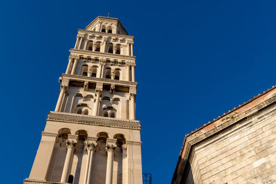 Low angle view of clock tower against clear blue sky