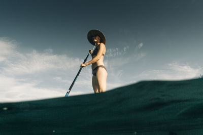 A young woman enjoys a standup paddle board on lost lake in oregon.